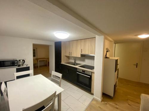 a kitchen and dining room with a table and a white table and a kitchen at Gemütliches Wohnung für Familien und Gruppen in Küblis