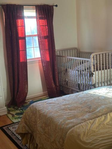 a bedroom with a crib and a window at Honey Home in Danville