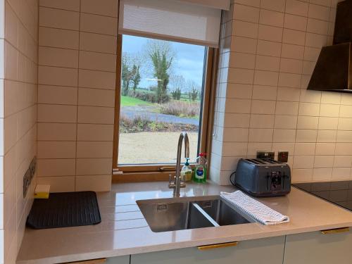 a kitchen counter with a sink and a window at Cluain Alainn in Cashel