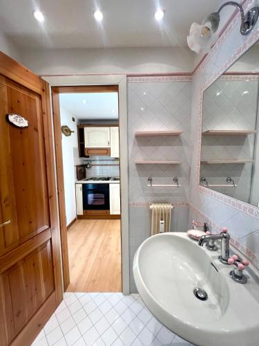 a bathroom with a sink and a kitchen at Monolocale Collini in Madonna di Campiglio