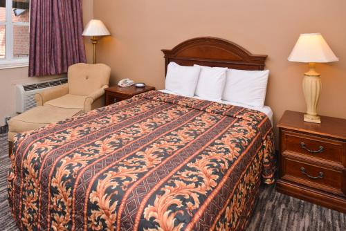 a hotel room with a bed and a chair at Ranch House Motel in Sweetwater