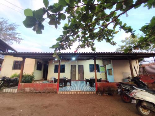 een huis met een veranda en een tafel ervoor bij Chaitanya Beach Reesort in Dapoli