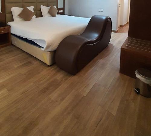 een slaapkamer met een bed en een houten vloer bij mashotelabha in Abha