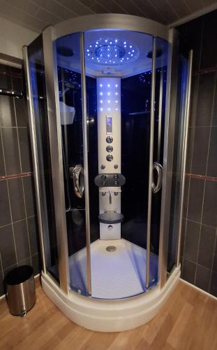 a small shower in a bathroom with blue lights at Ferienhaus Christiane in Schoenberg