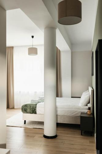 a bedroom with a bed and a white column at Wilczy Sen in Ciechanów