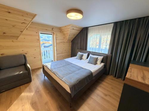 Un dormitorio con una cama y una silla dentro. en Chokolate house, en Bukovel