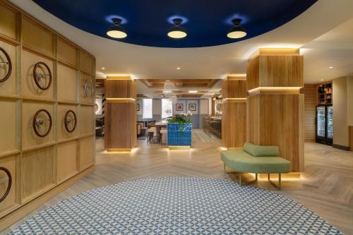 a large room with a green chair and a table at Hotel Indigo Detroit North - Troy by IHG in Troy