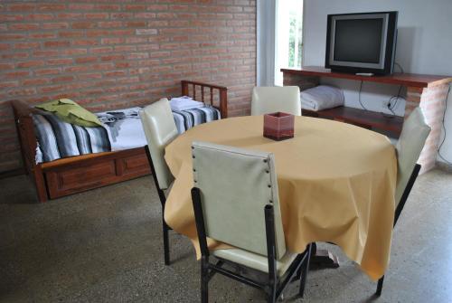 a room with a table with chairs and a bed at El Chinchero Departamentos in Merlo