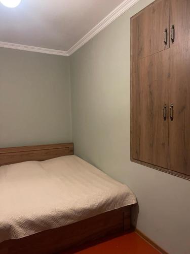 una piccola camera con letto e armadio in legno di Gimara Kazbegi a Kazbegi