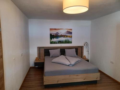 een slaapkamer met een bed in een kamer met een lamp bij Panorama Apartment in Bruck am Ziller
