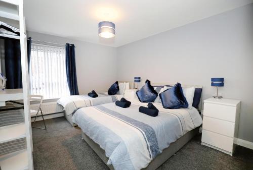 a bedroom with two beds with blue pillows at Harbour View City Centre Apartment in Belfast