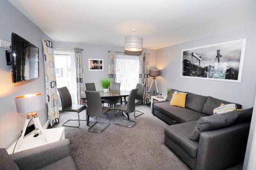 a living room with a couch and a table at Harbour View City Centre Apartment in Belfast