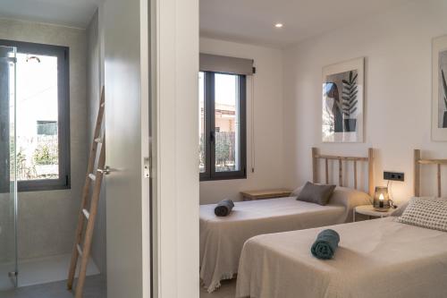 a hotel room with two beds and a window at s'ANDRONA in Ciutadella