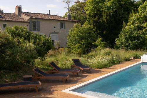 a swimming pool with lounge chairs next to a house at la chaume st martin in Angoulême