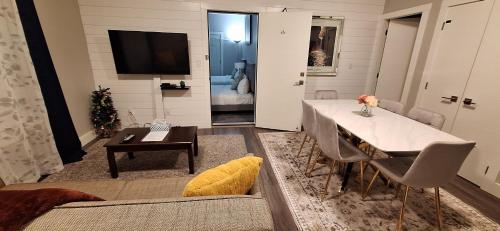 a living room with a dining table and a television at Two Bedroom Suite with AC, Sleeps 8- Welcome Snacks and Drinks Included in Langford