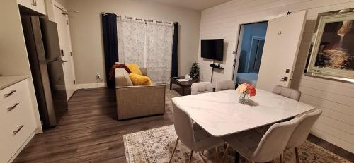 a living room with a white table and chairs at Two Bedroom Suite with AC, Sleeps 8- Welcome Snacks and Drinks Included in Langford