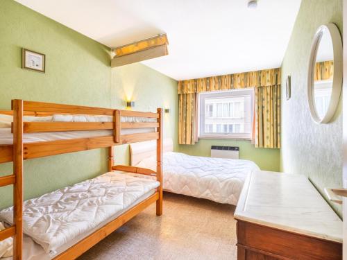 a bedroom with two bunk beds and a desk at Premieres Loges in Sint-Idesbald