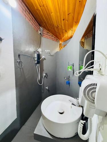a bathroom with a shower and a white sink at Rice Rice Villas in Tissamaharama