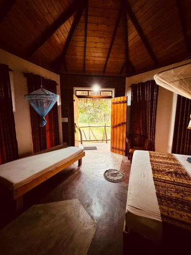 a bedroom with two beds and a window with a view at Rice Rice Villas in Tissamaharama