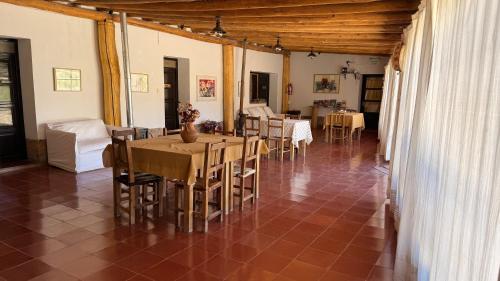 a dining room with tables and chairs in a house at Hostería Viñas de Uquia in Capla