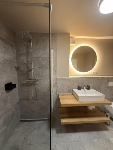 a bathroom with a shower and a sink and a mirror at Bergflamme - Ihr Ferienhaus im Harz mit Panoramasauna in Braunlage