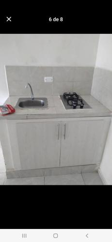 a white kitchen with a sink and a stove at Casa estrella in Manizales