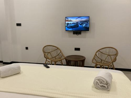 een kamer met een tafel met stoelen en een tv aan de muur bij Ocean Edge Holiday Resorts in Hiriketiya