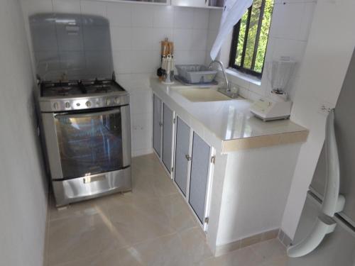 a small kitchen with a stove and a sink at Posada Sweet Anashly in Providencia