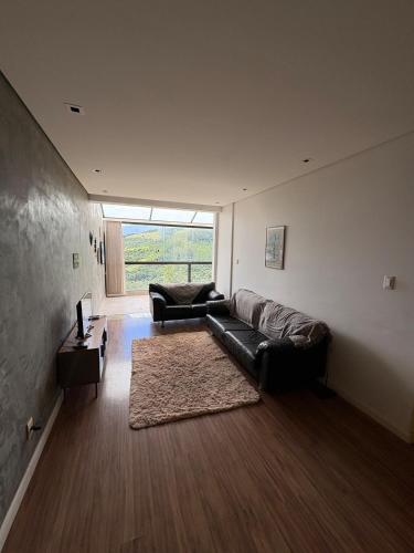 a living room with a couch and a table at Apartamento Inteiro Próximo ao Centro in Águas de Lindoia