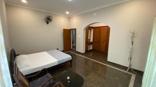 een slaapkamer met een bed en een tafel in een kamer bij Abida Mansion 4BHK Near MCP Convention Centre IJK in Irinjālakuda