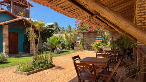 un patio con tavoli e sedie in un cortile di POUSADA DONNA MARIA a São Miguel do Gostoso