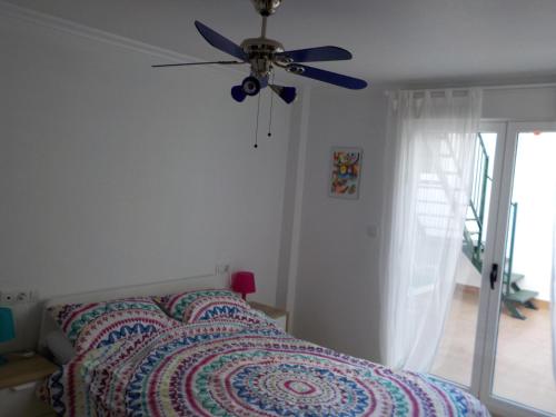 a bedroom with a bed with a ceiling fan at Attic at 91 in Pinoso