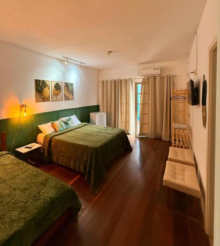 a hotel room with two beds and a window at Hotel Montanas in Nova Friburgo