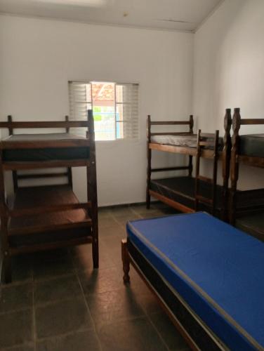 una stanza con tre letti a castello e una finestra di Chácara Recanto Girassol a Biritiba-Mirim