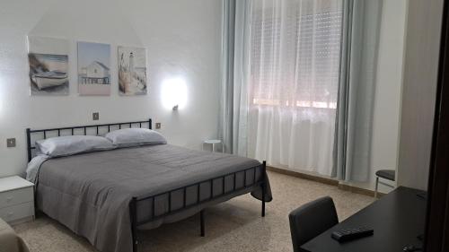 ein weißes Schlafzimmer mit einem Bett und einem Fenster in der Unterkunft La casa del capitano in Tarquinia