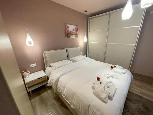 a bedroom with a white bed with towels on it at Elpida's Retreat, Pelion in Tsagarada