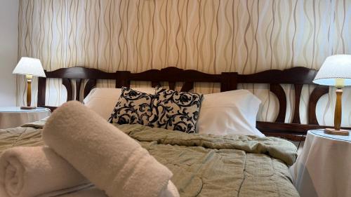 a bedroom with a bed with pillows and two lamps at Gran Hotel Mar del Plata in Mar del Plata