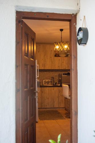 a kitchen with a door open to a kitchen with a microwave at Elpida's Retreat, Pelion in Tsagarada