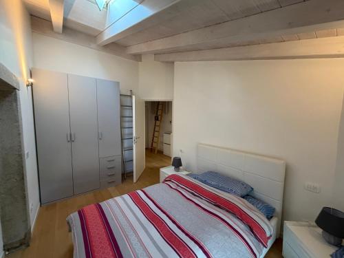 a bedroom with a bed and a white wall at La Piccola Perla di Rovereto in Rovereto