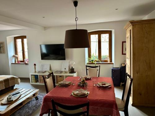 un soggiorno con tavolo e tovaglia rossa di Loft à colombages "1789" - 80m2 a Innenheim