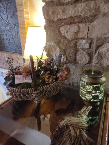 a table with a lamp and a basket of flowers at Alojamiento Rural Tres Palacios in Molina de Aragón