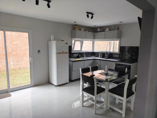 马德普拉塔Casa la florida的配有桌椅和冰箱的厨房