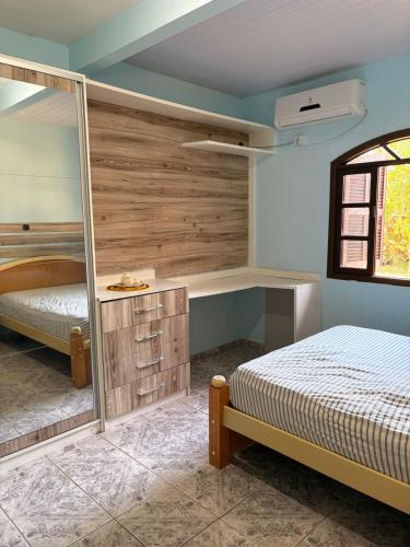 een slaapkamer met een bed en een grote spiegel bij Casa em Itapoá - Barra do Saí in Itapoa