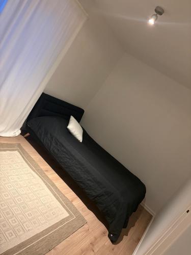 a bedroom with a black bed with a white pillow at High Coast Stay Floor 1 in Ramvik