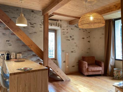 een kamer met een trap, een tafel en een stoel bij Gîte Le COCON au Clarou in Valleraugue
