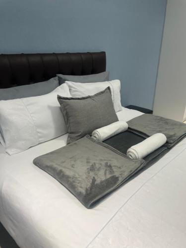 a bed with two blankets and pillows on it at RT Guest House in Walvis Bay