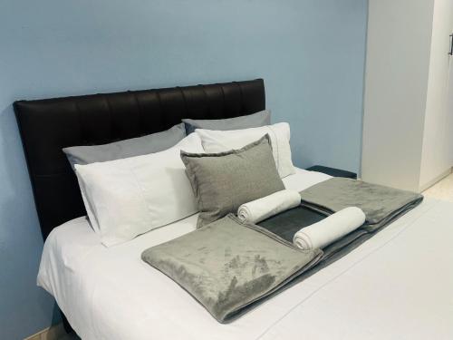 a bed with white sheets and pillows on it at RT Guest House in Walvis Bay