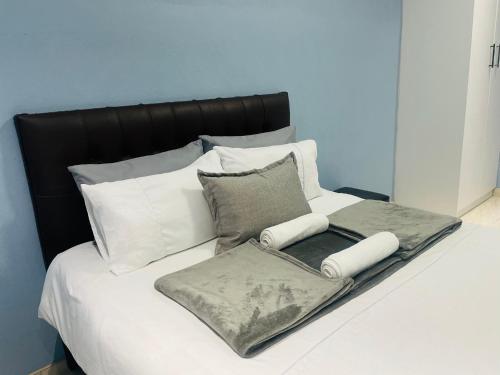 a bed with two blankets and pillows on it at RT Guest House in Walvis Bay