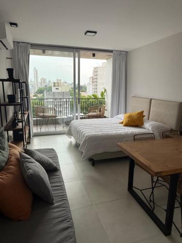 une chambre avec un lit, un canapé et une table dans l'établissement Departamento Estudio Deluxe, à La Plata