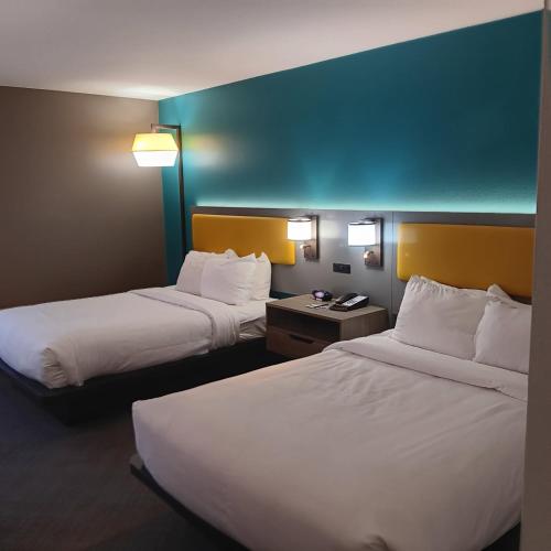 a hotel room with two beds and a blue wall at Comfort Inn North of Asheville in Mars Hill